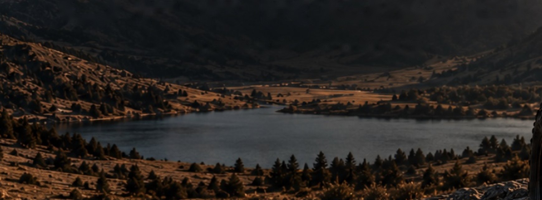 Een bergmeer tussen herfstkleurige hellingen en dennenbossen